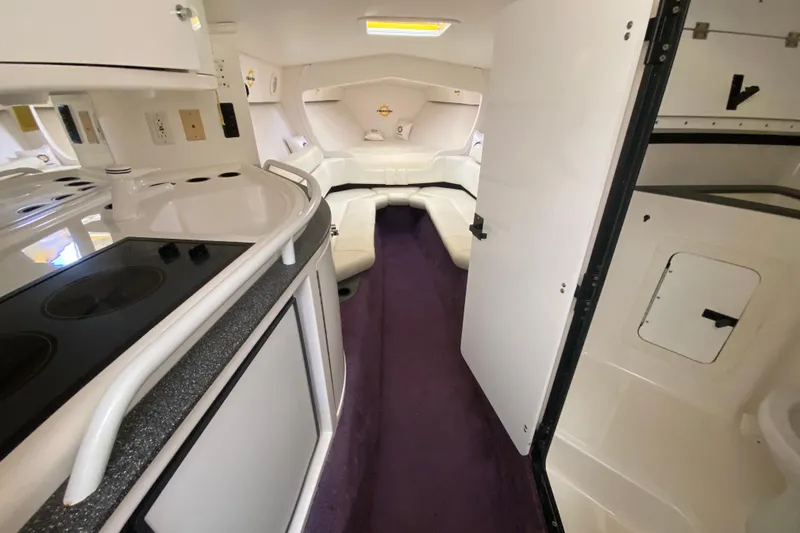 Slide: The Image of Interior of a 1999 Fountain 47 Lightning boat with white seating and kitchenette. - 27