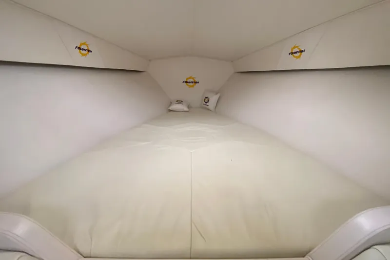 Slide: The Image of 1999 Fountain 47 Lightning boat interior cabin with white bedding and branded pillows. - 33