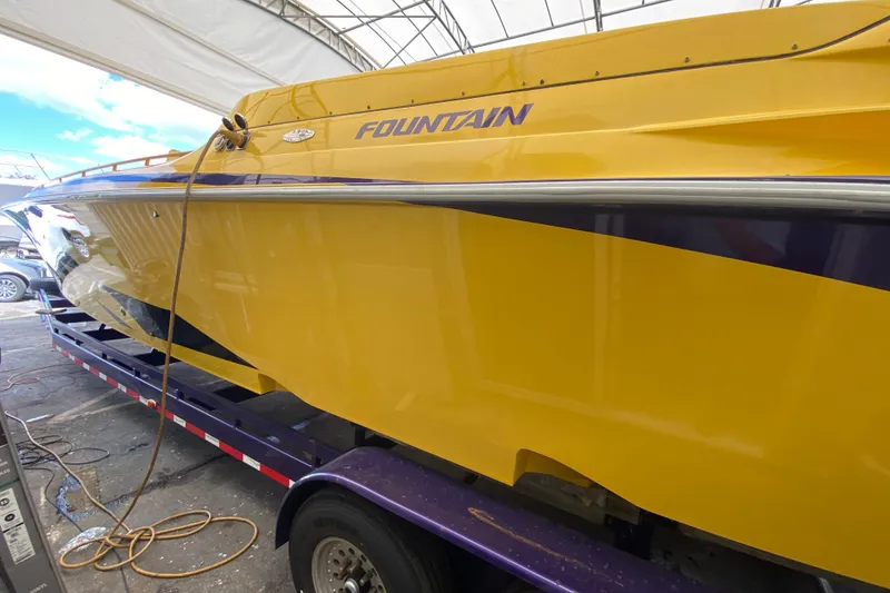 Slide: The Image of Yellow 1999 Fountain 47 Lightning boat on trailer under canopy. - 35