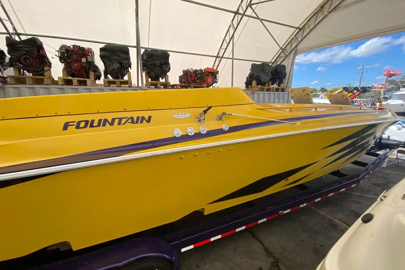 Slide: The Image of Yellow 1999 Fountain 47 Lightning speedboat in storage, surrounded by engines. - 38