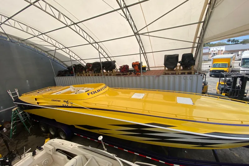 Slide: The Image of Yellow 1999 Fountain 47 Lightning boat under a large canopy. - 4