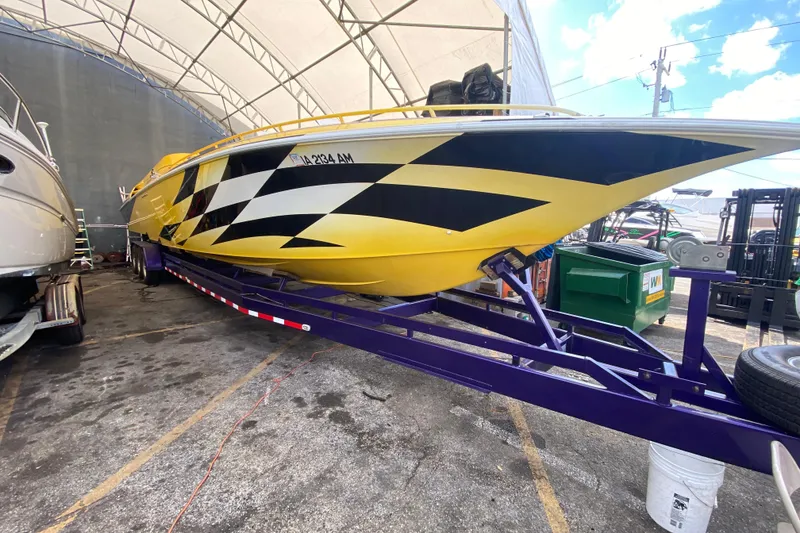Slide: The Image of Yellow 1999 Fountain 47 Lightning boat on trailer under canopy. - 5