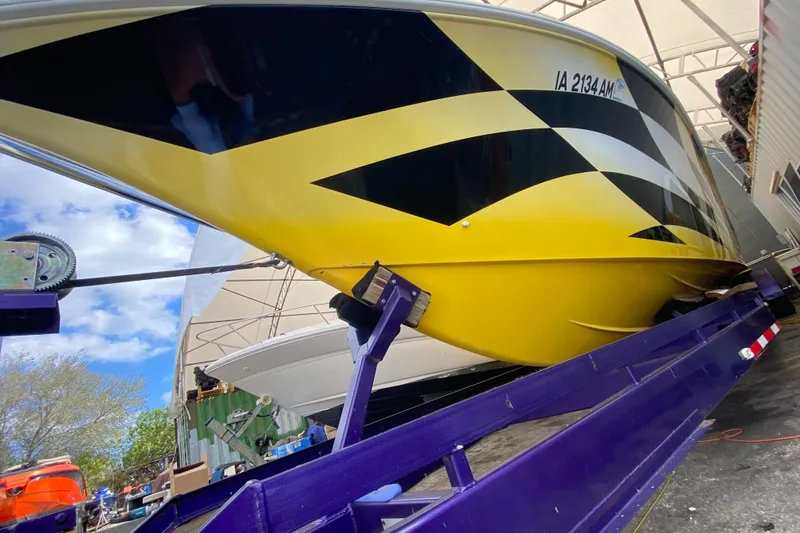 Slide: The Image of 1999 Fountain 47 Lightning boat with vibrant yellow and black design on a trailer. - 8