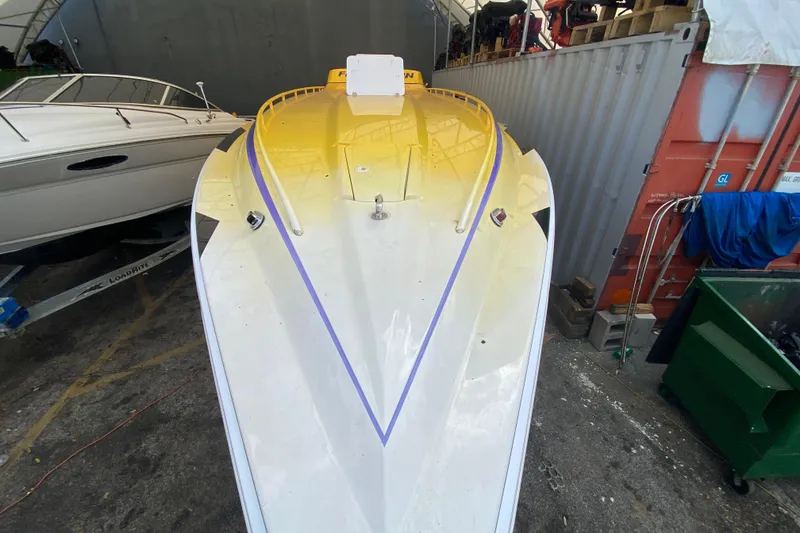 Slide: The Image of 1999 Fountain 47 Lightning boat with yellow and white design in a storage area. - 9