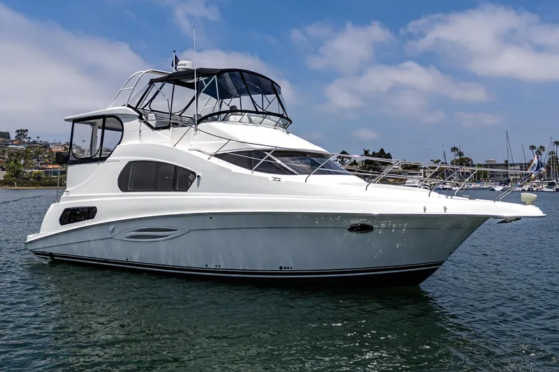 The Image of 2004 Silverton 39 Motor Yacht on calm water under a clear blue sky. - 0