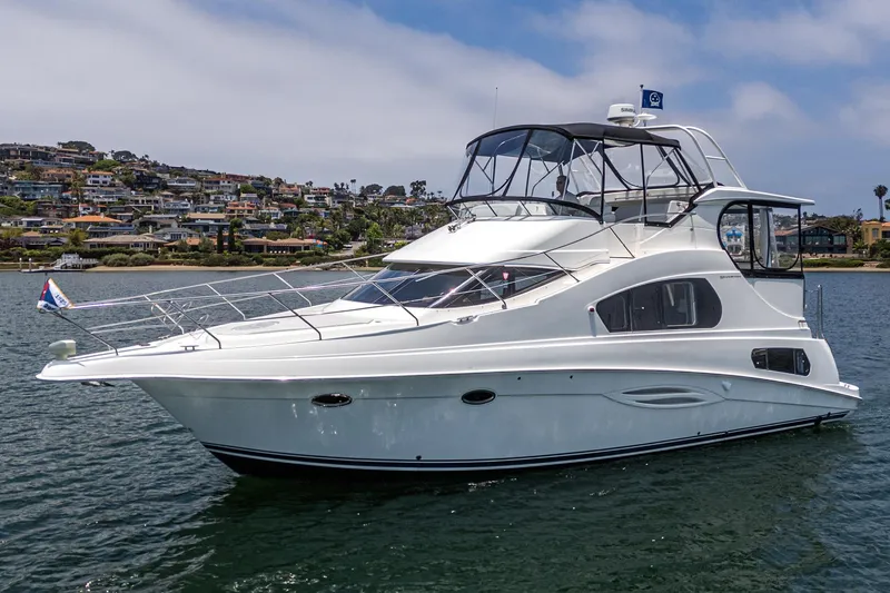 The Image of 2004 Silverton 39 Motor Yacht on water, coastal background, clear sky. - 1