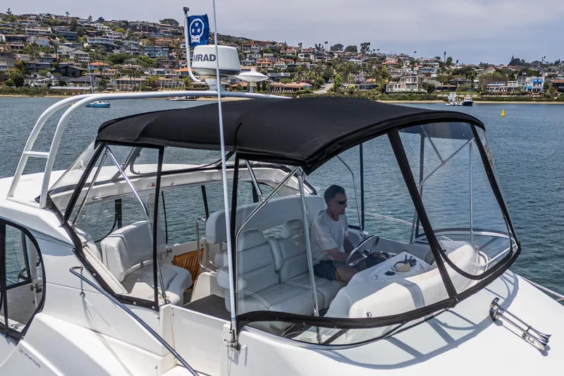 Slide: The Image of 2004 Silverton 39 Motor Yacht cruising on a scenic waterway with hillside homes in the background. - 14