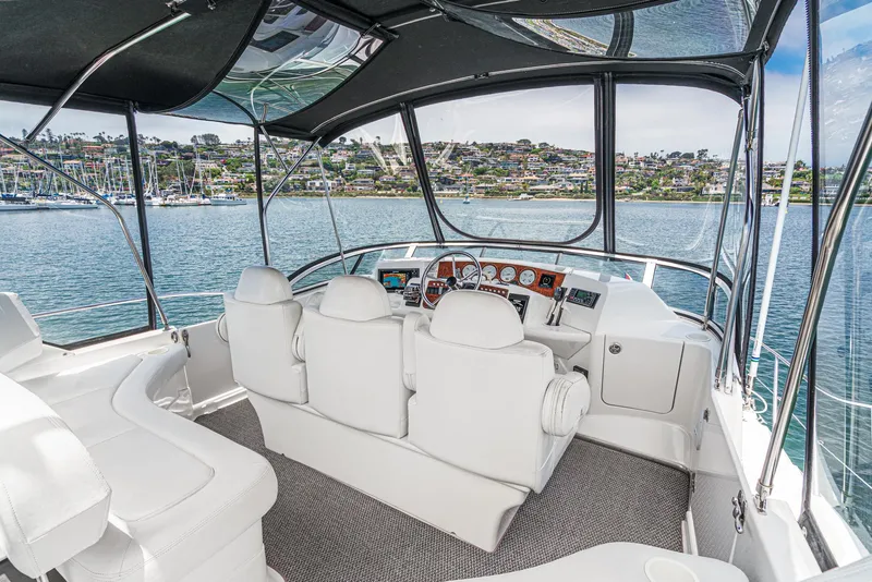 Slide: The Image of 2004 Silverton 39 Motor Yacht interior with helm, overlooking scenic waterfront. - 15