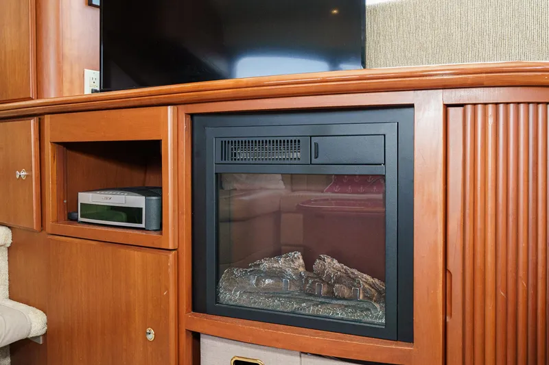 Slide: The Image of 2004 Silverton 39 Motor Yacht interior with built-in fireplace and wooden cabinetry. - 27