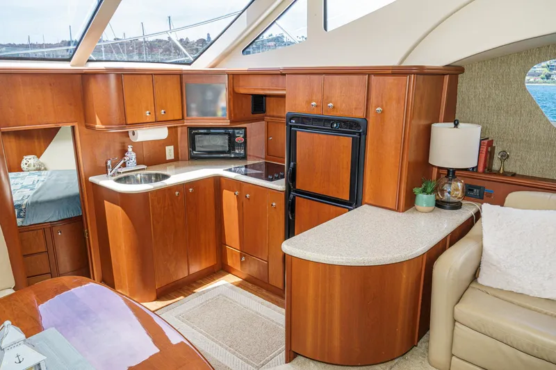 Slide: The Image of 2004 Silverton 39 Motor Yacht interior with modern kitchen, wood cabinetry, and natural light. - 29