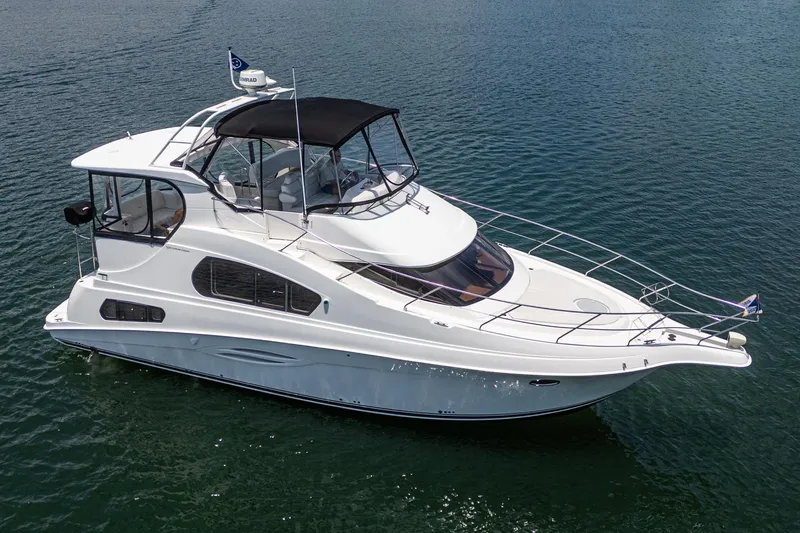 Slide: The Image of 2004 Silverton 39 Motor Yacht on calm water, featuring sleek design and spacious deck. - 3