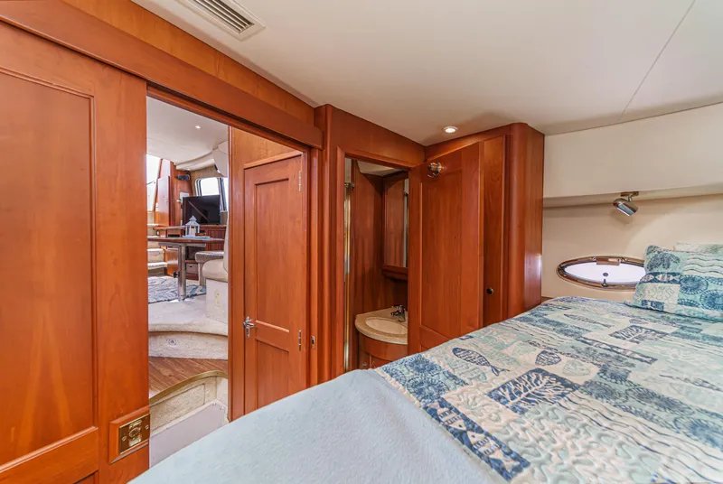 Slide: The Image of 2004 Silverton 39 Motor Yacht interior with wood paneling and cozy bedroom. - 31