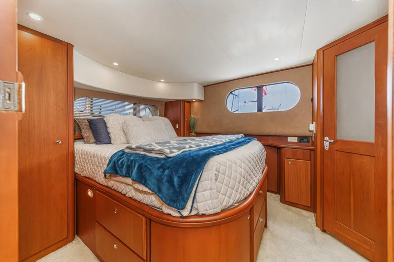 Slide: The Image of Luxurious cabin interior of 2004 Silverton 39 Motor Yacht with cozy bed and wooden furnishings. - 32