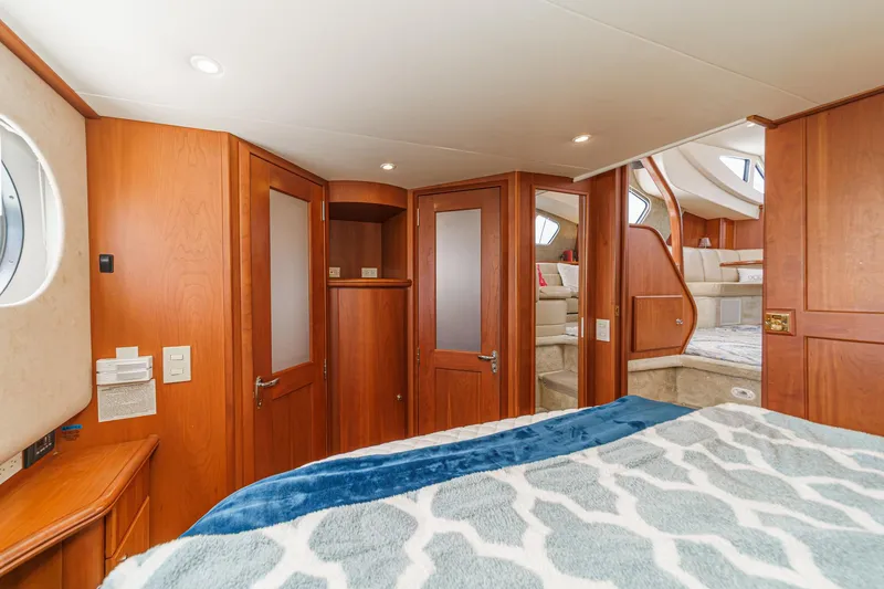 Slide: The Image of 2004 Silverton 39 Motor Yacht interior with wood paneling and cozy bedroom. - 33