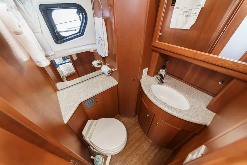 Slide: The Image of 2004 Silverton 39 Motor Yacht bathroom with wood cabinetry, sink, and porthole window. - 34