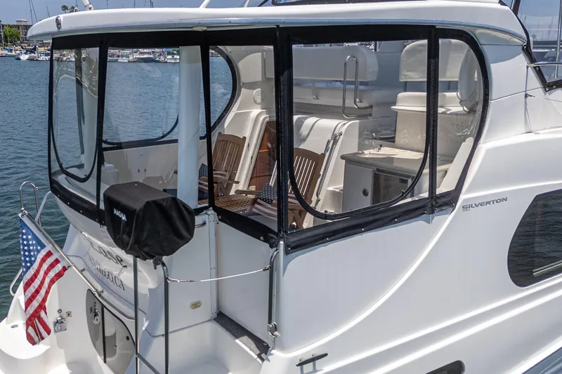 Slide: The Image of 2004 Silverton 39 Motor Yacht with American flag, docked in marina. - 8