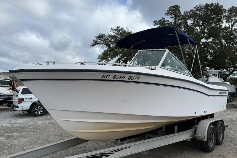 Slide: The Image of 2000 Grady-White Freedom 225 boat on trailer, parked outdoors under cloudy sky. - 3