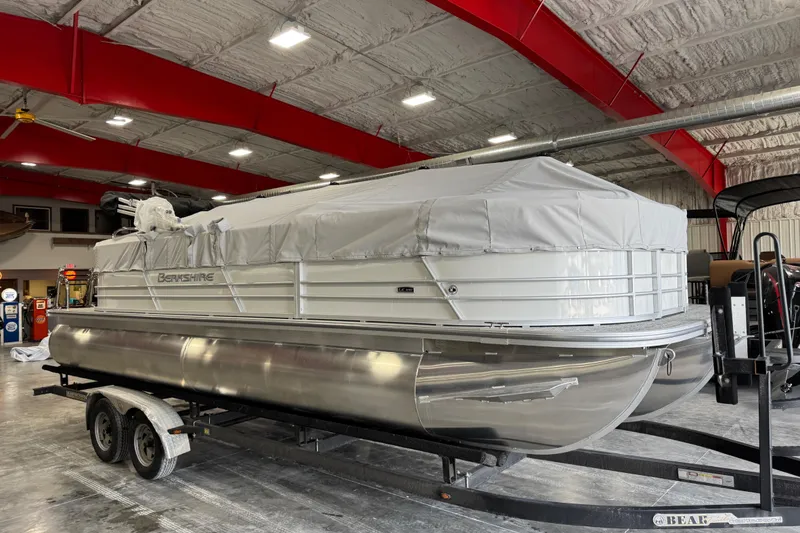 Slide: The Image of 2026 Berkshire 24RFX LE pontoon boat covered and on trailer in indoor showroom. - 7