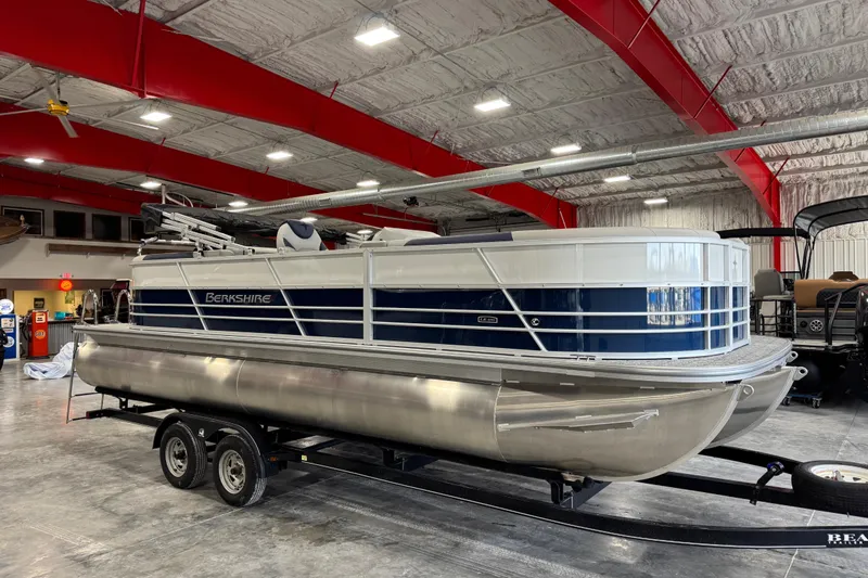 Slide: The Image of 2026 Berkshire 24RFX LE pontoon boat in showroom, featuring sleek design and modern amenities. - 2
