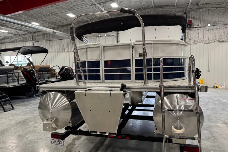 Slide: The Image of 2026 Berkshire 24RFX LE pontoon boat in a showroom, rear view with ladder. - 4