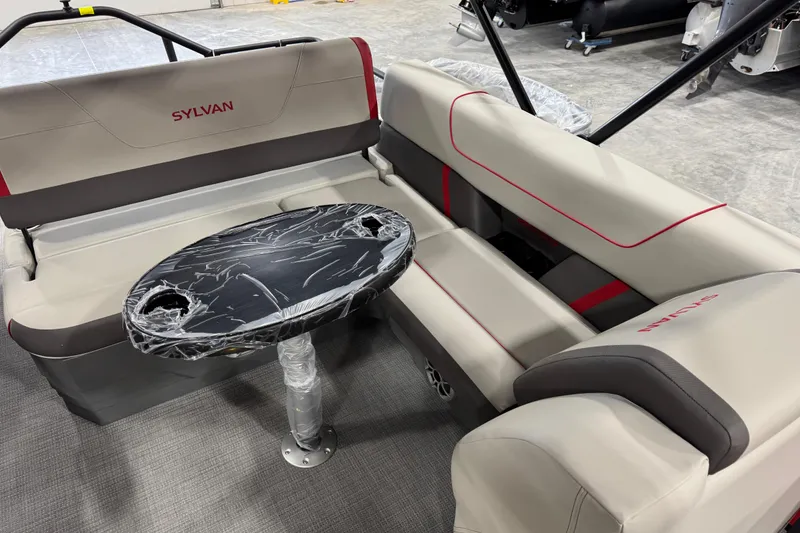 Slide: The Image of 2026 Sylvan X-5 boat interior with beige seating and a black oval table. - 13