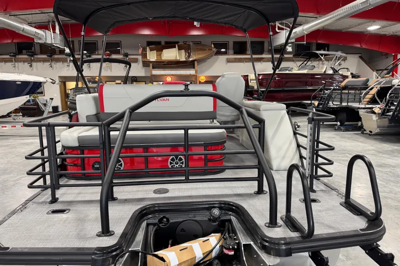 Slide: The Image of 2026 Sylvan X-5 boat interior with red and gray seating, displayed in a showroom. - 4