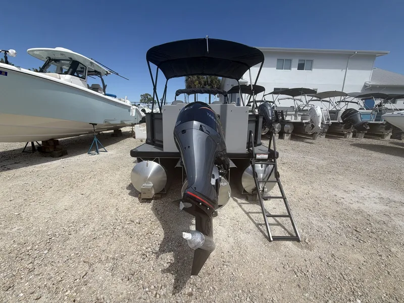 Slide: The Image of Sweetwater 2286 FS 2026 pontoon boat with outboard motor on gravel lot. - 15