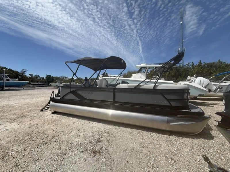 Slide: The Image of 2026 Sweetwater 2286 FS pontoon boat on gravel lot under blue sky. - 9