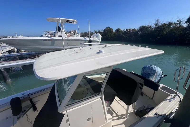 Slide: The Image of 2015 Scout 255 LXF boat docked on calm water under clear blue sky. - 17