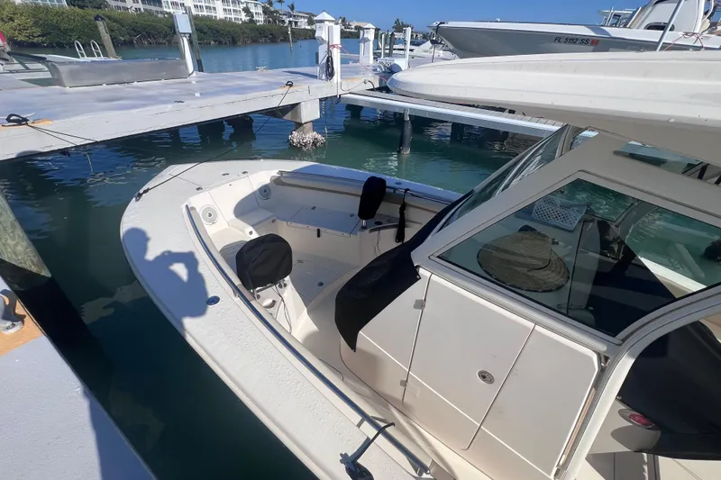 Slide: The Image of 2015 Scout 255 LXF boat docked at marina, sunny day, clear water. - 18