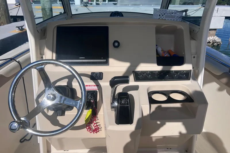 Slide: The Image of 2015 Scout 255 LXF boat dashboard with steering wheel and controls. - 19