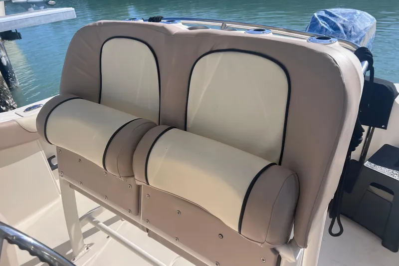 Slide: The Image of 2015 Scout 255 LXF boat seats with beige and cream upholstery by the water. - 20