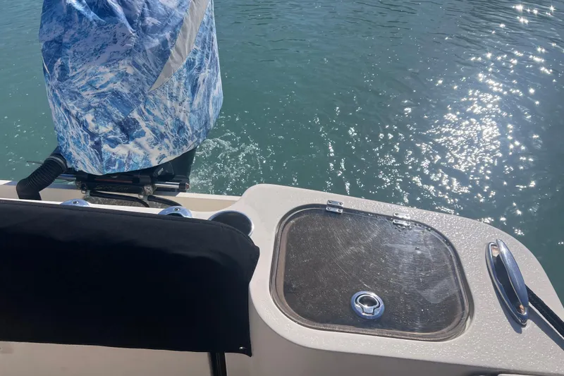 Slide: The Image of 2015 Scout 255 LXF boat with covered engine, sparkling water in background. - 22