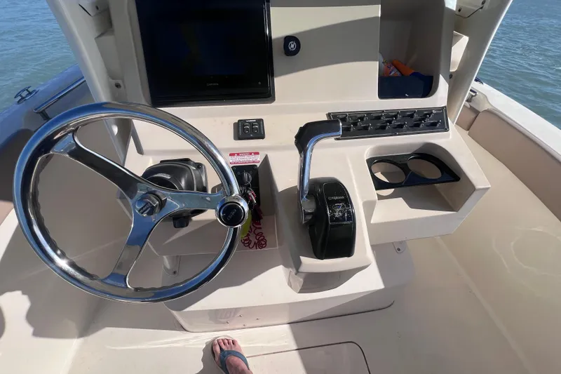 Slide: The Image of Steering console of a 2015 Scout 255 LXF boat with controls and cup holders. - 26