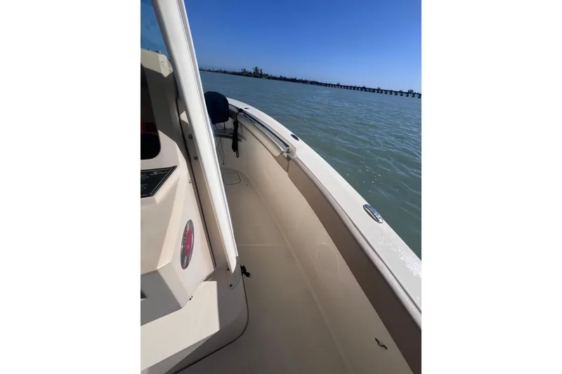 Slide: The Image of 2015 Scout 255 LXF boat on calm water under clear blue sky. - 27