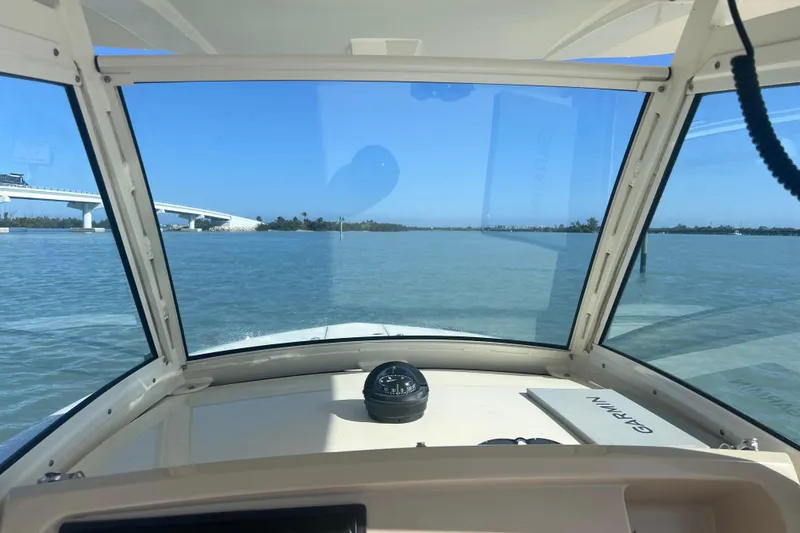 Slide: The Image of View from 2015 Scout 255 LXF boat cockpit, overlooking calm waters and distant bridge. - 29