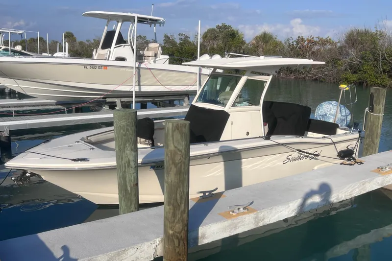 Slide: The Image of 2015 Scout 255 LXF boat docked in a marina, sunny day, calm waters. - 34