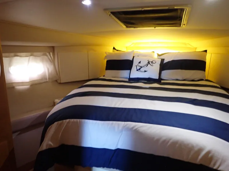 Slide: The Image of Cozy bedroom in 1996 Carver 370 Voyager with nautical-themed bedding and soft lighting. - 10
