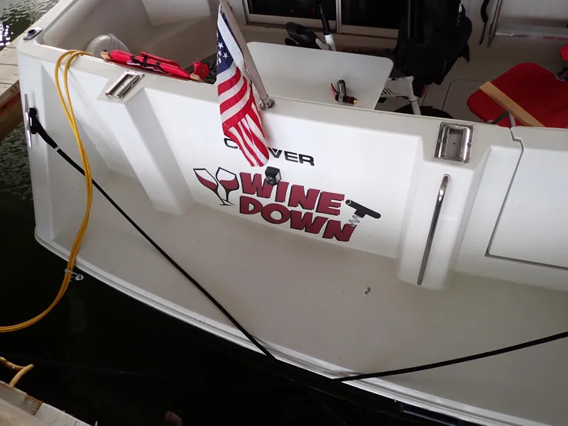 Slide: The Image of 1996 Carver 370 Voyager boat with "Wine Down" decal and American flag. - 19