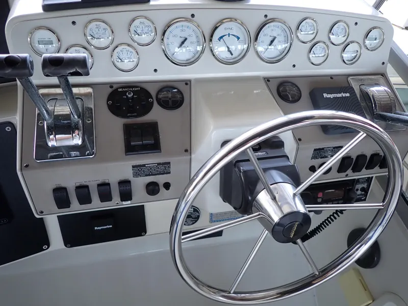 Slide: The Image of Control panel of a 1996 Carver 370 Voyager boat with gauges and steering wheel. - 21
