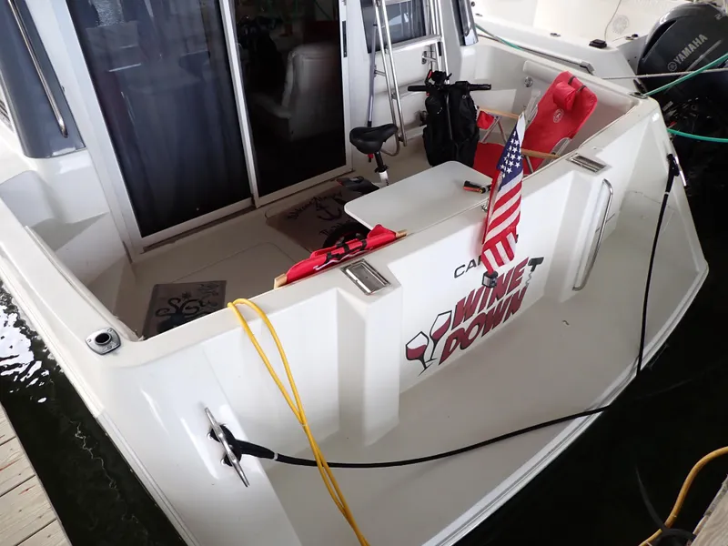 Slide: The Image of 1996 Carver 370 Voyager boat with American flag, docked, featuring outdoor seating and equipment. - 3