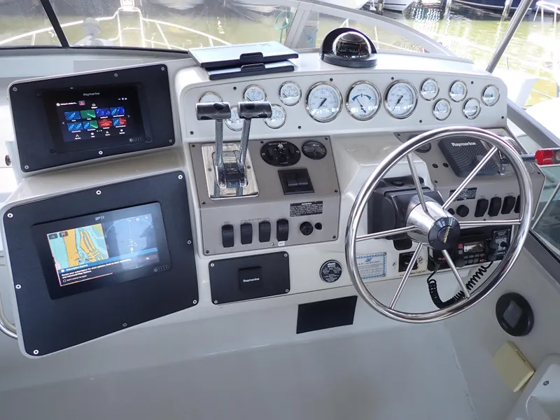 Slide: The Image of 1996 Carver 370 Voyager helm with gauges, dual screens, and steering wheel. - 4