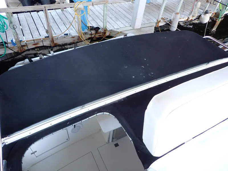 Slide: The Image of 1996 Carver 370 Voyager boat with black canvas cover docked at marina. - 47