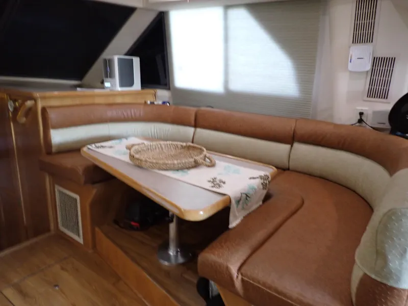 Slide: The Image of Interior of a 1996 Carver 370 Voyager with a cozy dining area and brown seating. - 8