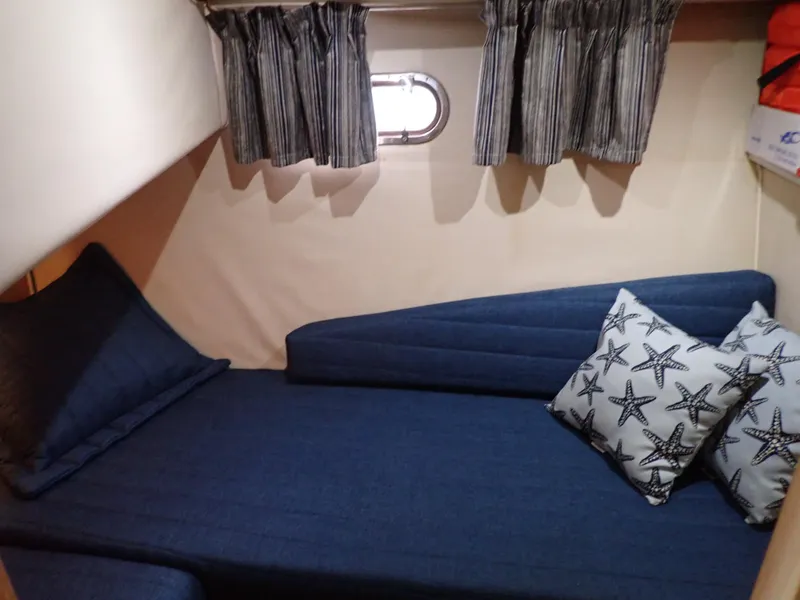 Slide: The Image of Cozy cabin interior of 1996 Carver 370 Voyager with blue bedding and starfish pillows. - 11