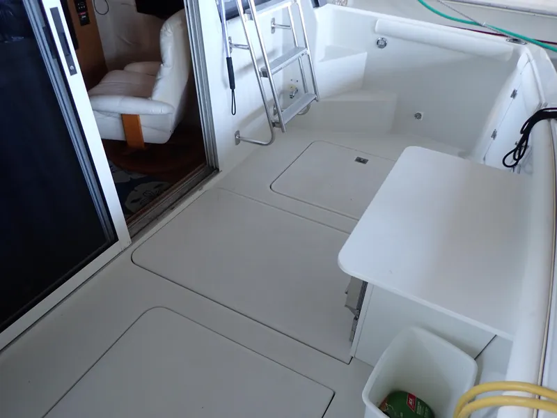 Slide: The Image of 1996 Carver 370 Voyager yacht deck with seating, ladder, and storage compartments. - 18