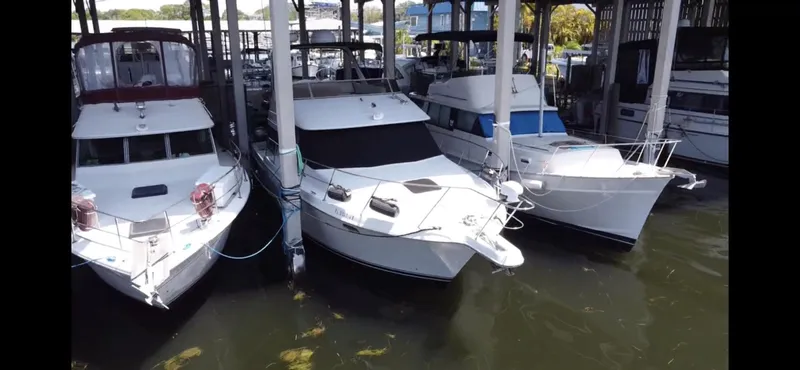 Slide: The Image of Three yachts docked in a marina, featuring a 1996 Carver 370 Voyager. - 2