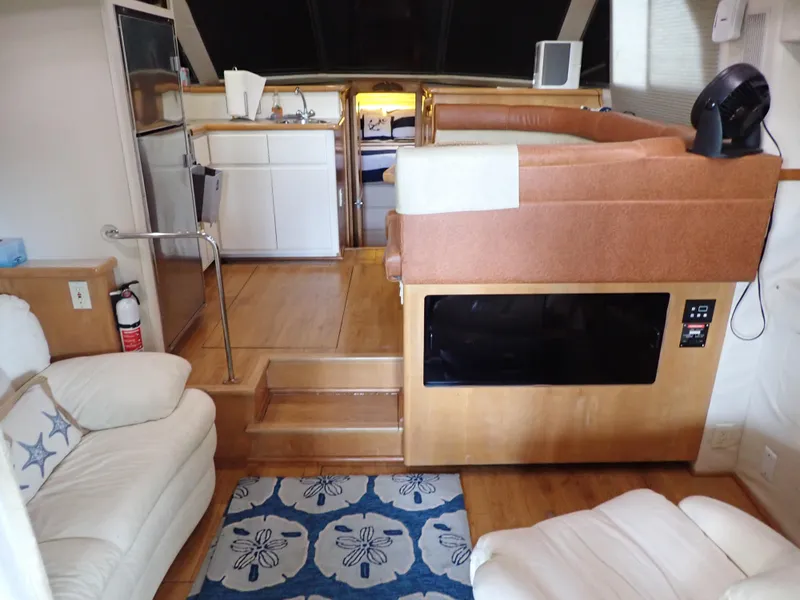 Slide: The Image of Interior of a 1996 Carver 370 Voyager yacht with cozy seating and kitchenette. - 6