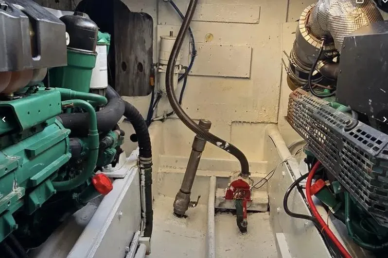 Slide: The Image of Engine room of a 1978 Uniflite 50 boat, featuring mechanical components and piping. - 10