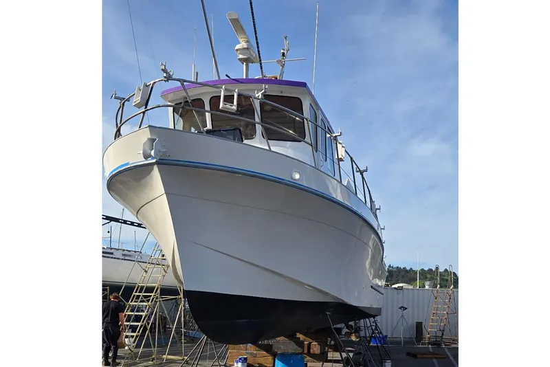 Slide: The Image of 1978 Uniflite 50 boat on dry dock, undergoing maintenance under clear blue sky. - 12